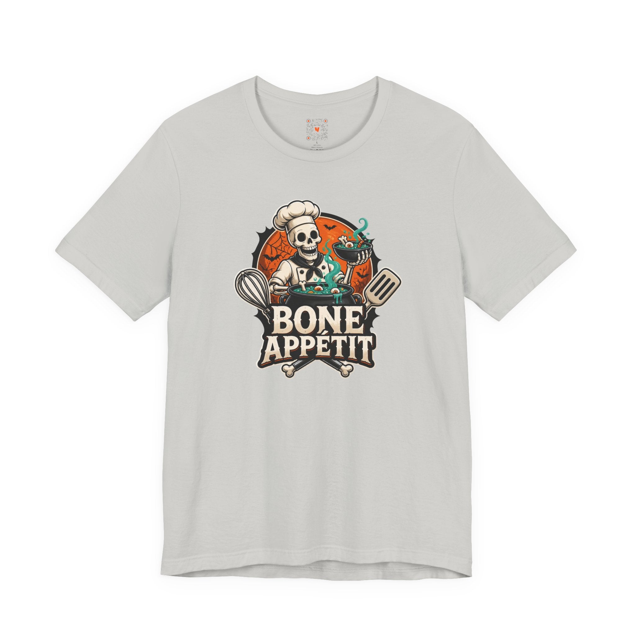 A skeleton-themed graphic t-shirt surrounded by candy, autumn leaves, and cozy Halloween decor